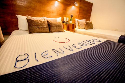 a hotel room with two beds with the word extremes at Hotel del Carmen, en el Centro- DESAYUNO Incluido ! in Tuxtla Gutiérrez