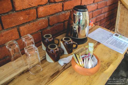 a wooden table with a coffee pot on top of it at Square Peg in Kandy