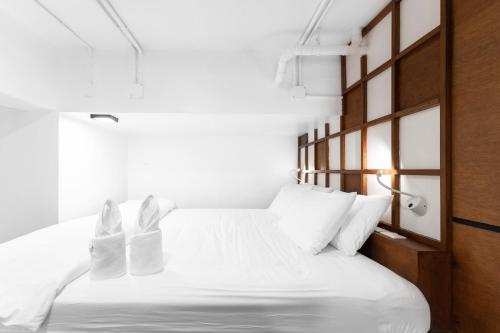 a bedroom with a white bed with white pillows at Book a Bed Poshtel - SHA Plus in Phuket Town