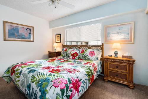 Un dormitorio con una cama con una colcha floral. en Kona Plaza#402, en Kailua-Kona