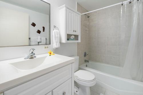 Un baño blanco con lavabo e inodoro. en Kona Plaza#402, en Kailua-Kona