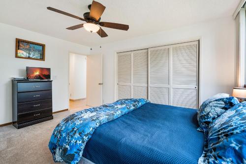 a bedroom with a blue bed and a ceiling fan at Keauhou Kona Surf & Racquet Club #6-104 in Kailua-Kona