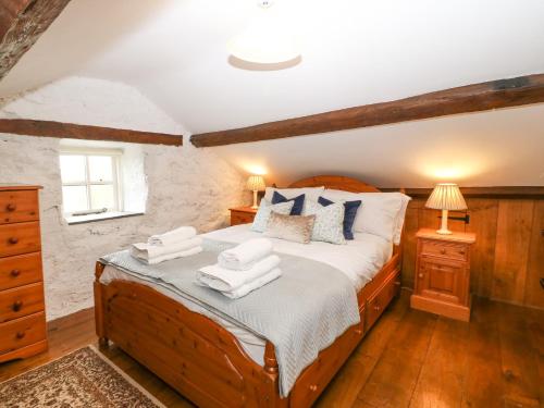 a bedroom with a large wooden bed with pillows at Nant Bach in Pwllheli