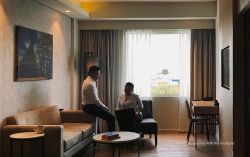 two people sitting in a living room with a couch at Park Inn By Radisson Bacolod in Bacolod