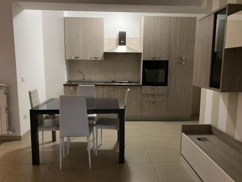 uma cozinha com uma mesa de jantar e cadeiras em ALMA Casa Vacanze Cosenza em Cosenza