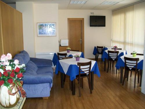 a living room with a blue couch and tables and chairs at Hotel Sol de la Blanca in Cudillero