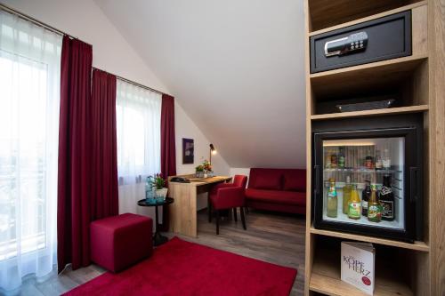 a living room with a red couch and a table at Arcus Hotel München Messe in Feldkirchen