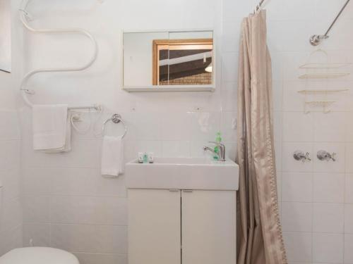 ein Badezimmer mit einem Waschbecken, einem WC und einem Spiegel in der Unterkunft Clearview 2 8 Bogong Street in Jindabyne