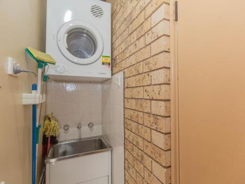 a washing machine above a sink in a bathroom at Clearview 2 8 Bogong Street in Jindabyne