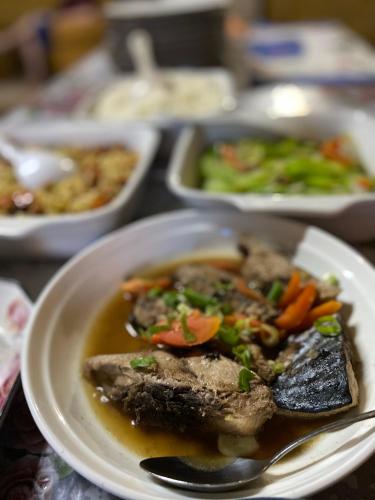 a plate of food with meat and vegetables on a table at Compass Diving Resort in Beloi