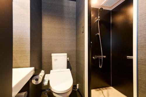 a bathroom with a toilet and a sink and a shower at HOTEL TAVINOS Kyoto in Kyoto