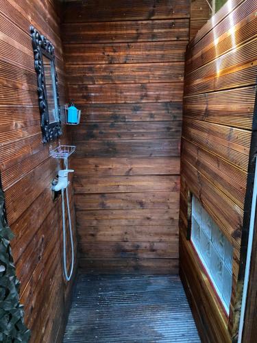 a bathroom with a wooden wall with a shower at Séjour avec SPA **** sous le soleil ou sous les étoiles in Vauvert
