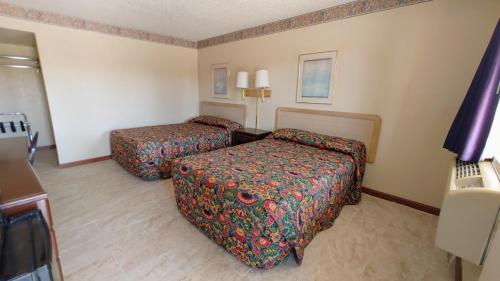 ein Hotelzimmer mit 2 Betten und einem Schreibtisch in der Unterkunft Time Motel in Nogales