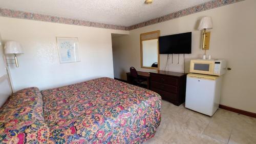 ein Hotelzimmer mit einem Bett und einem TV in der Unterkunft Time Motel in Nogales