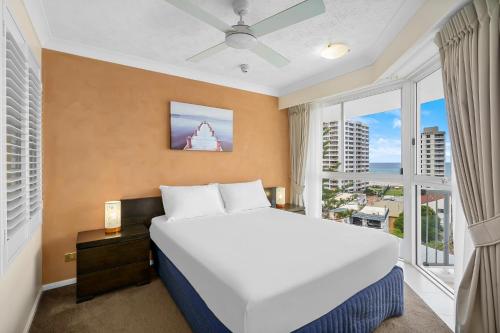 a bedroom with a large bed and a large window at Surf Parade Resort in Gold Coast