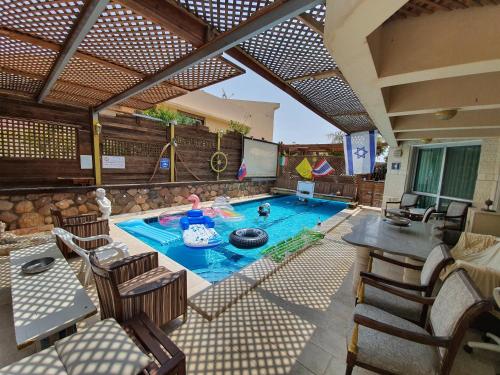 una piscina al aire libre con mesa, sillas, mesa y mesa en Thai villa eilat - וילה תאי אילת, en Eilat