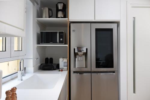 a kitchen with a refrigerator and a microwave at Scalinada Luxury Suites in Corfu Town