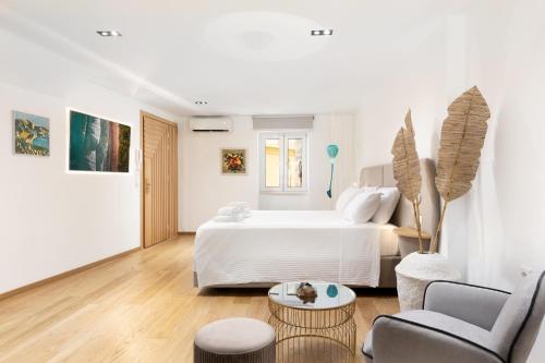 a white bedroom with a bed and a living room at Scalinada Luxury Suites in Corfu Town