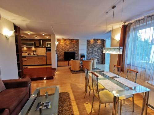 a living room and dining room with a table and chairs at Uroczy apartament przy deptaku z parkingiem. in Polanica-Zdrój