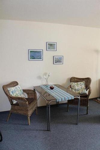 een woonkamer met een tafel en 2 stoelen bij Appartement 1 Haus Residenz in Sankt Peter-Ording