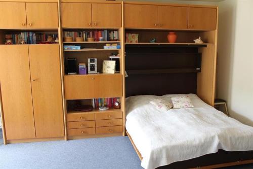een slaapkamer met een bed en houten boekenplanken bij Appartement 1 Haus Residenz in Sankt Peter-Ording