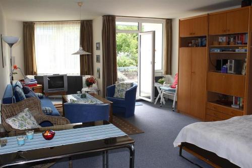 een woonkamer met een bed en een woonkamer met een bank bij Appartement 1 Haus Residenz in Sankt Peter-Ording