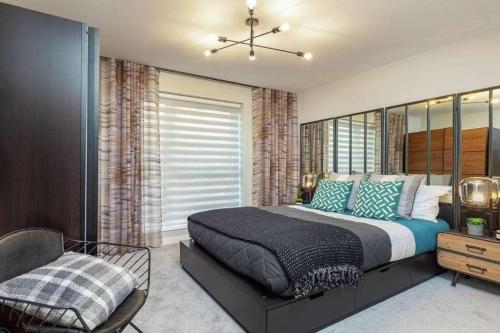 um quarto com uma cama e uma cadeira em Newly Built Luxury 2 Bed Apartment!!! em Londres