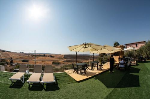 a person standing in a field with chairs and umbrellas at B&B Villa Kairos in Agrigento