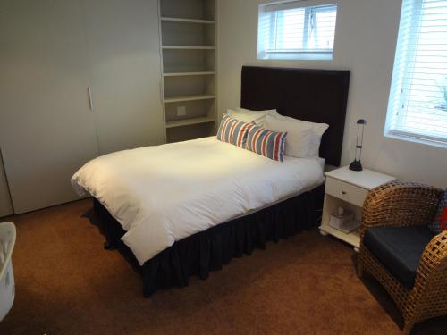 a bedroom with a large white bed and a chair at Designer Studio Camps Bay in Cape Town