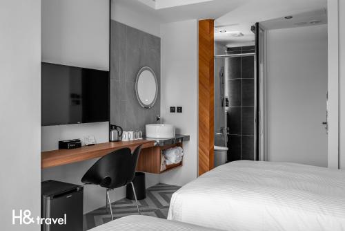 a bedroom with a bed and a desk with a mirror at Black Horn B&B in Hengchun
