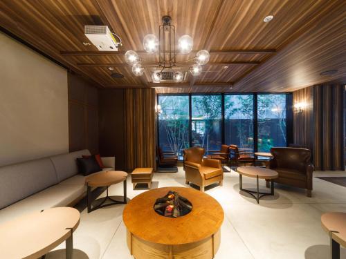 a living room with a couch and a table and chairs at Susukino Granbell Hotel in Sapporo