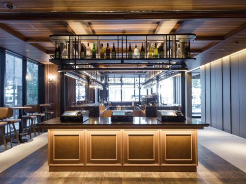 a bar in a room with some bottles on a shelf at Susukino Granbell Hotel in Sapporo