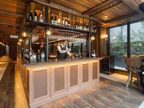 a man standing at a bar in a restaurant at Susukino Granbell Hotel in Sapporo