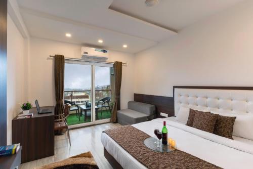 a bedroom with a bed and a living room with a table at Blizzard Resort in Panchgani