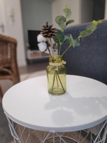 a glass vase with a flower on a white table at Agréable T2 neuf -le DÔME- in Riom