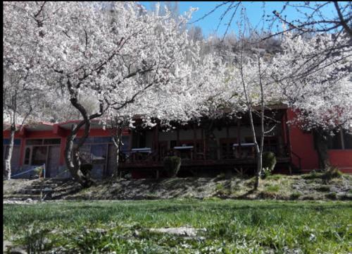 a red house with trees in front of it at Northern Sapphire in Hunza