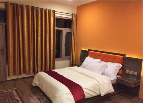 a bedroom with a large bed and a window at Northern Sapphire in Hunza