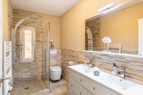 a bathroom with a shower and a sink and a mirror at Villa Felicidad in Font de Sa Cala
