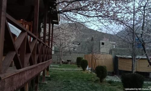 a yard with a fence and a mountain in the background at Northern Sapphire in Hunza