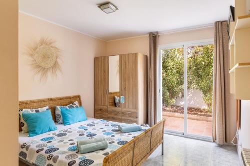 a bedroom with a bed with blue pillows at Villa Felicidad in Font de Sa Cala