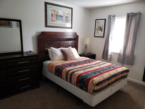 een slaapkamer met een bed, een dressoir en een spiegel bij Frayser Cozy Newly Renovated 8 BR Compound in Memphis