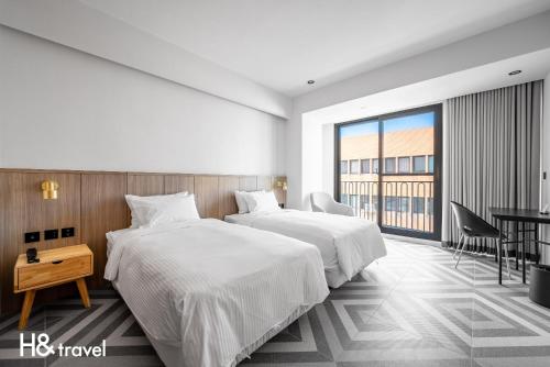 a hotel room with two beds and a desk at Black Horn B&B in Hengchun