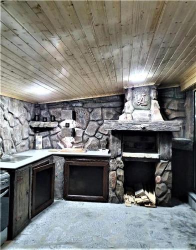 a stone kitchen with a stove and a fireplace at Aparthotel Alfa in Ureki