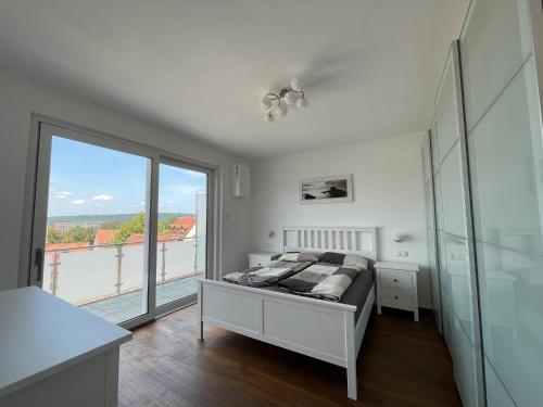 a bedroom with a bed and a large window at Ferienwohnung Seeblick in Pleinfeld
