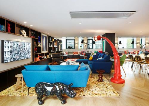a living room with blue couches and a red pole at citizenM Paris Champs-Élysées in Paris