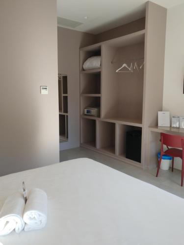 a bedroom with a white bed with two towels at SALAPIA SALIS RESORT in Margherita di Savoia