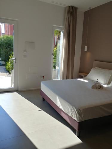 a bedroom with a large bed and a sliding glass door at SALAPIA SALIS RESORT in Margherita di Savoia