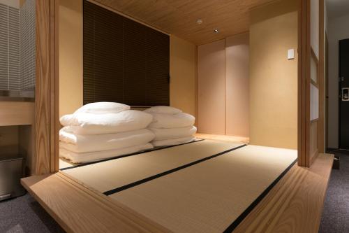 a room with a pile of towels on a bed at Design Hotel Kyoto Fuyacho in Kyoto