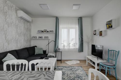 a living room with a couch and a table at Virágos Vendégház a Dunakanyarban, privát kerttel in Nagymaros