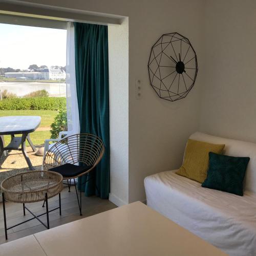 un salon avec un canapé et une table dans l'établissement COTTAGE 6 pers vue sur mer piscine, à Trévou-Tréguignec